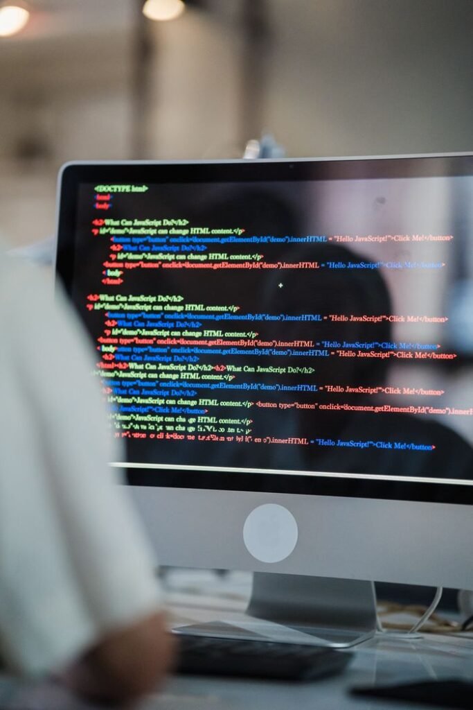 pexels photo 12899157 A close-up of a computer screen displaying colorful coding script in an office environment.